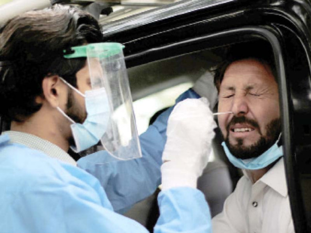 a paramedic uses a swab to take a nasal sample as he conducts a novel coronavirus test at a roadside testing facility in islamabad photo nni a paramedic uses a swab to take a nasal sample as he conducts a novel coronavirus test at a roadside testing facility in islamabad photo nni