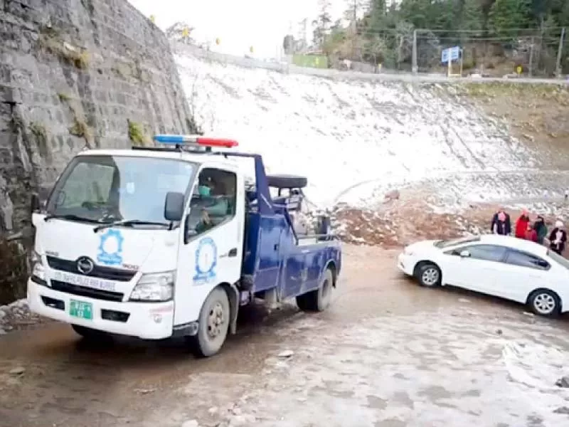a police truck tows a stranded car in murree during snowfall photo express a police truck tows a stranded car in murree during snowfall photo express