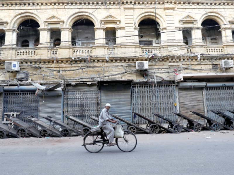 a hawker on bicycle rides past a closed wholesale cloth market in karachi most markets remained closed in the city on mon day amid a country wide strike photo reuters