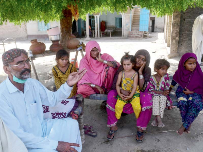 school teacher ali nawaz who helped with rescue efforts of the train collision gestures as he sits with his family at his home near the train acci dent site in daharki photo afp