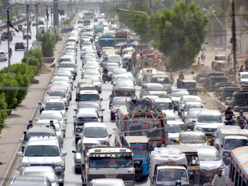 people are stuck in a traffic jam on a road in cliftion due to a protest of punjab colony residents against prolonged power outages photo express