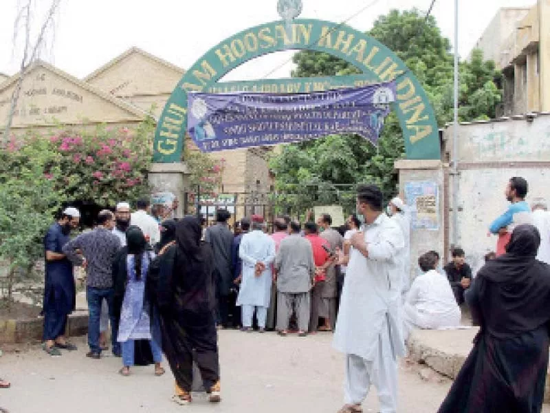 people stand outside the khaliqdina hall vaccination centre where gates were closed reportedly due to shortage of doses photo nni people stand outside the khaliqdina hall vaccination centre where gates were closed reportedly due to shortage of doses photo nni