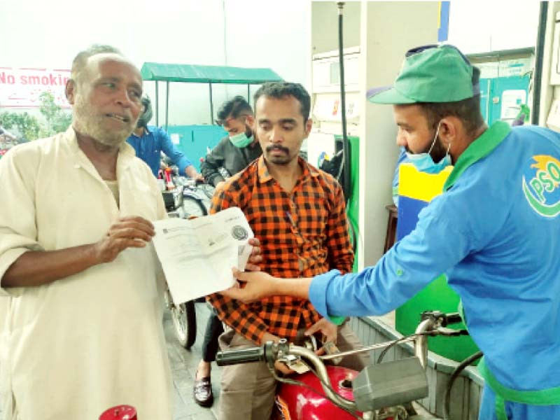 a worker checks the vaccination certificate of a man before refuelling his motorcycle at a gas refilling station in lahore as part of efforts to rein in the spread of covid photo rizwan anwar express