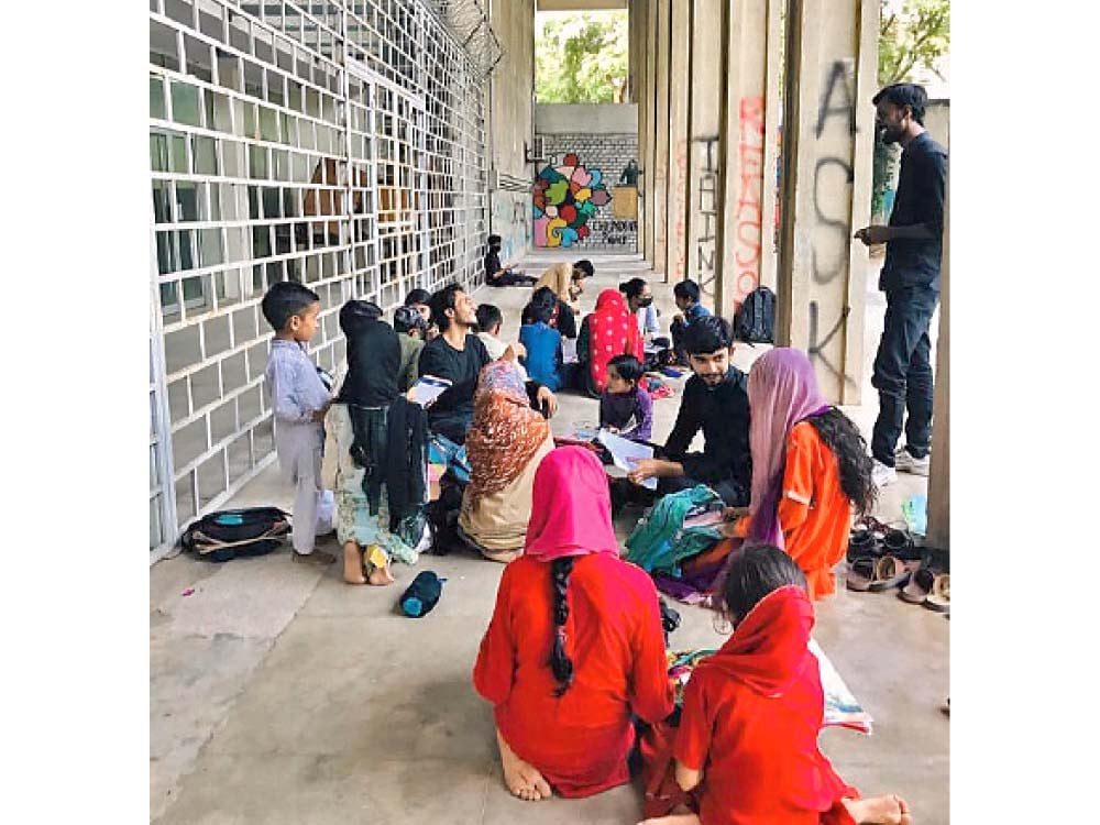 children revise their daily lessons while others sit with their instructors at a student led tutoring service at quaid e azam university islamabad photos express