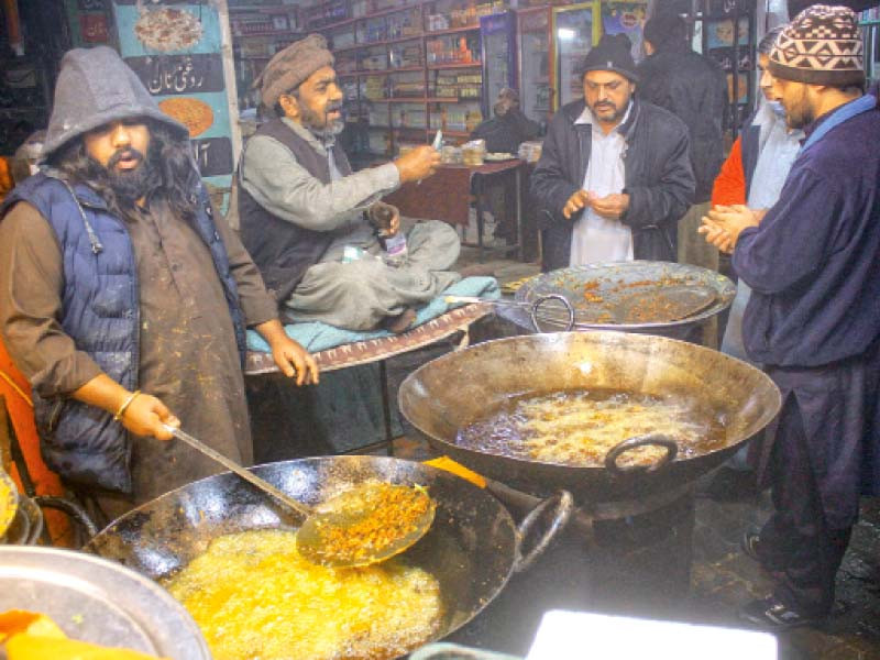 a cook prepares roasted fish at his shop at the melody market as demand for fried food increases due to rainy weather in the capital photo online