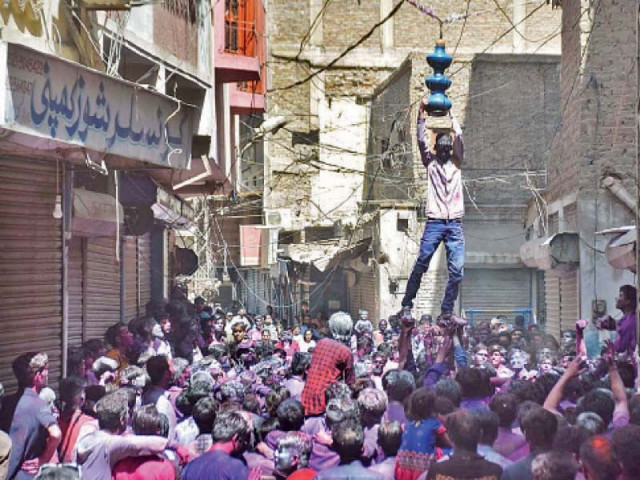 people of hindu community perform the ritual of breaking the pot on the occasion of holi in hyderabad photo online