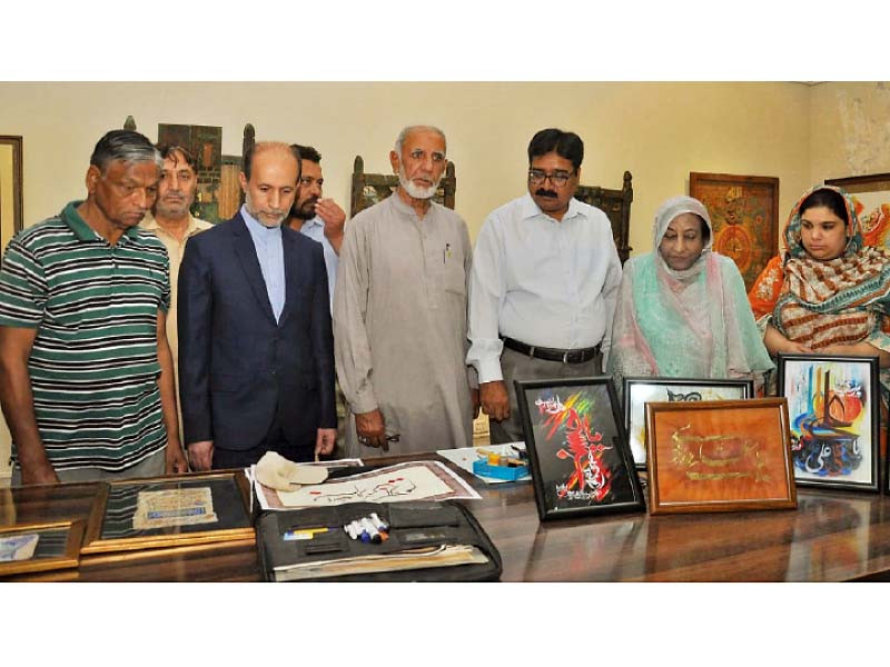 khaneh farhang iran director general faramarz rahmazad along with other visitors looks at the calligraphic artworks at the exhibition photo express