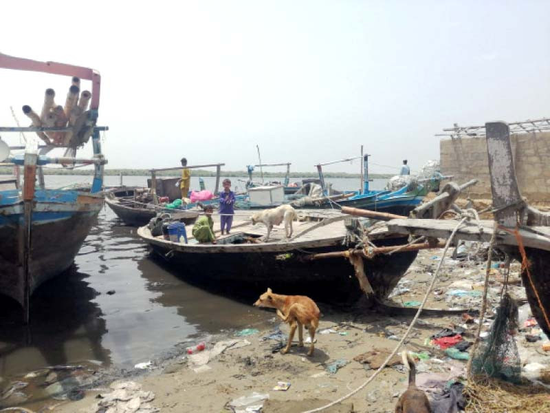 children in rehri goth play on a boat moored in water greyed by pollution due to discharge of effluent from factories and untreated sewerage photo express