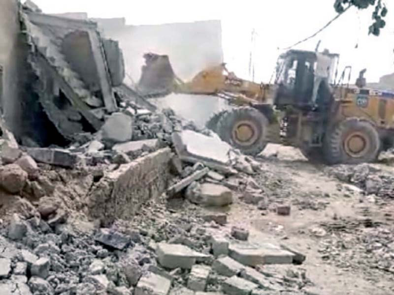 heavy machinery is razing illegal structures during an operation in surjani town on tuesday photo ppi