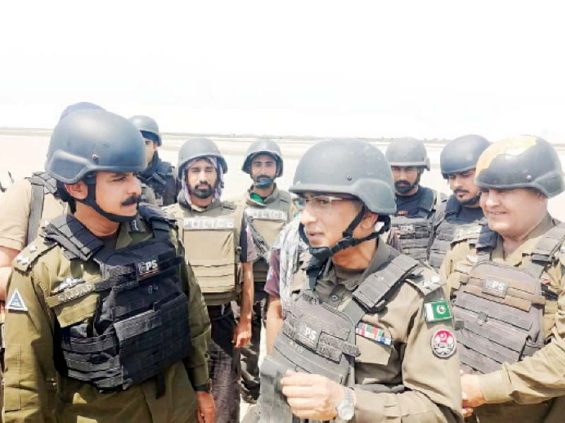 while a policeman glances across the area from an apc photos express