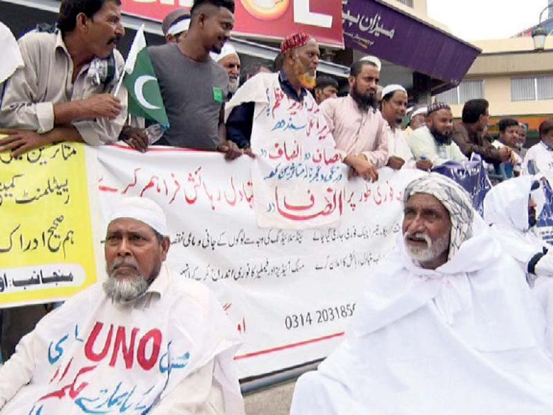 wearing burial shrouds or kafan people evicted from their homes during anti encroachment operation around the nullahs in karachi stage protest outside supreme court registry photo express