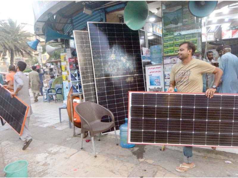 people carry off solar panels bought from a shop in the regal square area of saddar photo jalal qureshi express