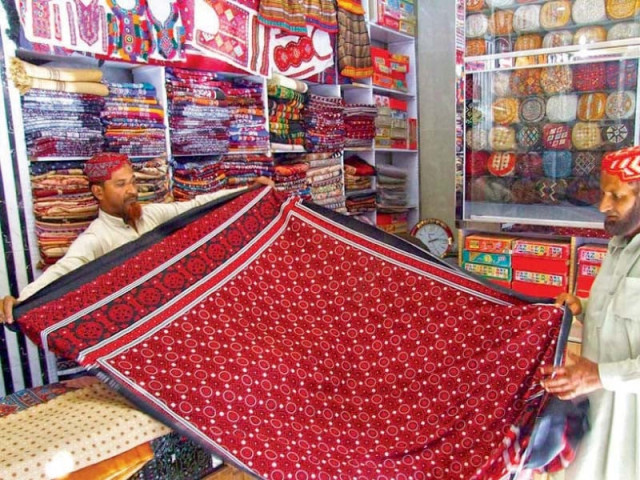 a shopkeeper shows an ajrak to a buyer at a shop in hyderabad photo online a shopkeeper shows an ajrak to a buyer at a shop in hyderabad photo online