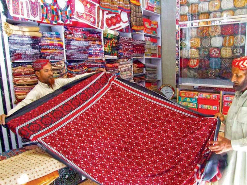 a shopkeeper shows an ajrak to a buyer at a shop in hyderabad photo online