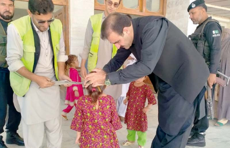 a child is being administered polio drops in bajaur photo nni