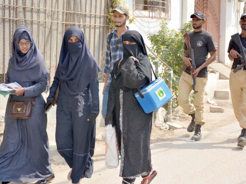 policemen accompany polio workers at a neighbourhood in karachi during the special vaccination drive launched on monday photo jalal qureshi express