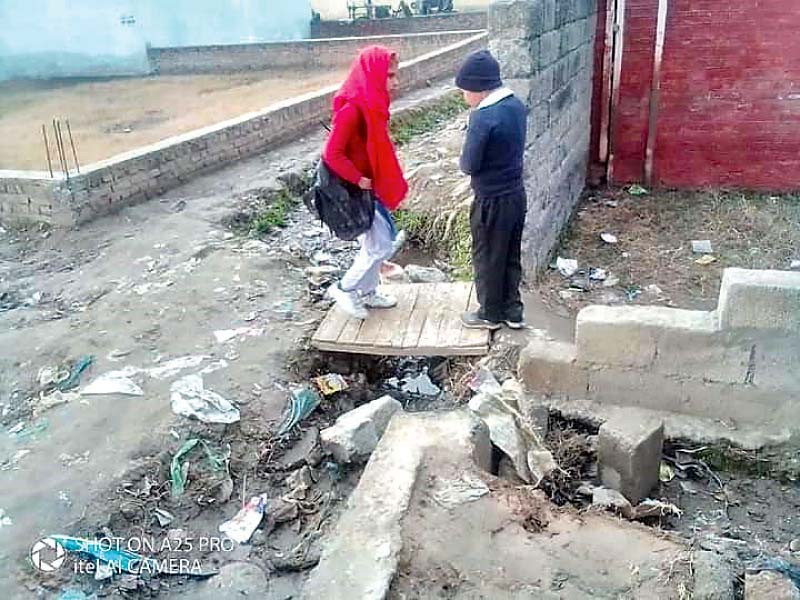 schoolchildren walk through unpaved streets during their daily commute in the vicinity of dheri makhan colony primary school in haripur photos express