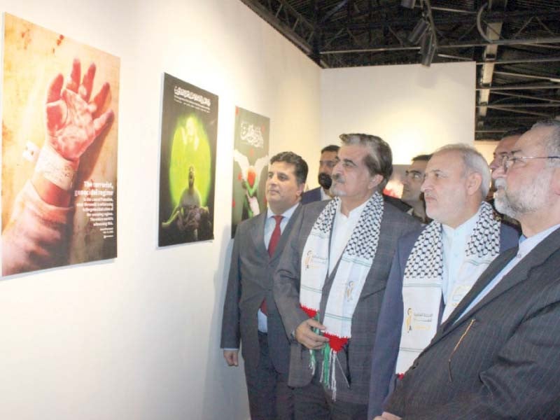 caretaker minister jamal shah observes portraits highlighting israeli brutalities along with iranian and syrian diplomats at lok virsa art gallery photo express