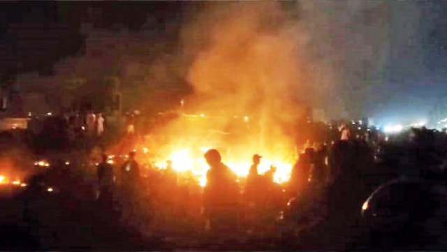 residents of ittehad town torch tyres during a protest to demand the arrest of the killers of two brothers hussain amin and farooq amin photo express