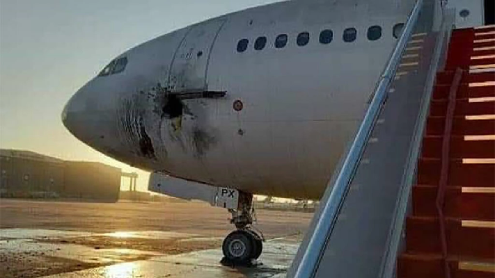 a handout picture released by the facebook page of the iraqi ministry of transportation shows a damaged stationary aircraft on the tarmac of baghdad airport after rockets reportedly targeted the runway on january 28 202 photo iraqi ministry of transportation facebook afp