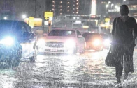 swamped cars pass a commuter on a flooded road near chiba metro station in chiba japan photo afp