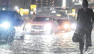 swamped cars pass a commuter on a flooded road near chiba metro station in chiba japan photo afp
