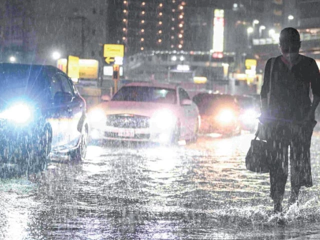 swamped cars pass a commuter on a flooded road near chiba metro station in chiba japan photo afp swamped cars pass a commuter on a flooded road near chiba metro station in chiba japan photo afp