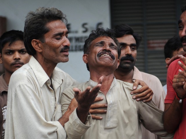 A Pakistani man mourns the death of relatives after a fire erupted in a garment factory in Karachi. PHOTO: AFP