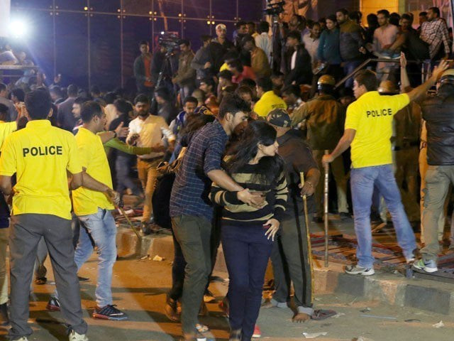 an indian man helps a woman c leave as police personnel try to manage crowds during new year 039 s eve celebrations in bangalore on january 1 2017 photo afp an indian man helps a woman c leave as police personnel try to manage crowds during new year 039 s eve celebrations in bangalore on january 1 2017 photo afp
