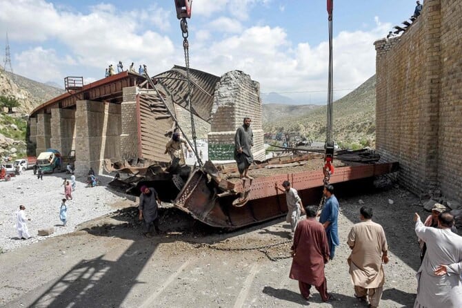 railway workers clear the wreckage of a collapsed railway bridge the morning after a blast by separatist militants at kolpur photo afp