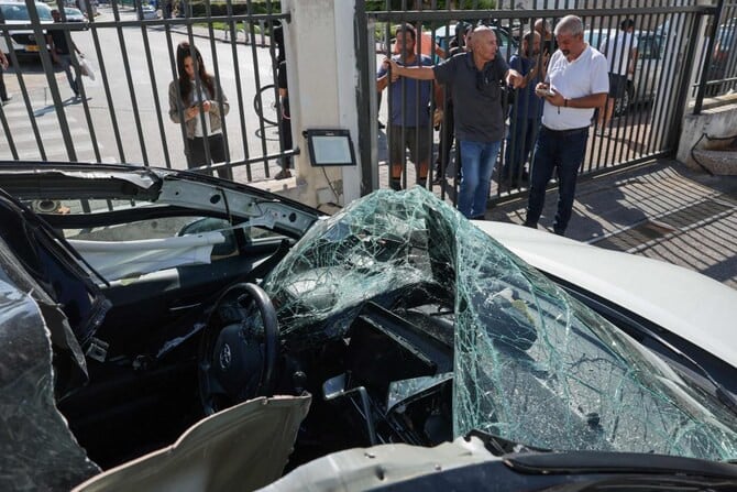 people look at a damaged car where an artillery shell fell before it was removed by israeli police in raanana near tel aviv on nov 6 2024 following a reported barrage of rockets launched from lebanon toward israel photo afp