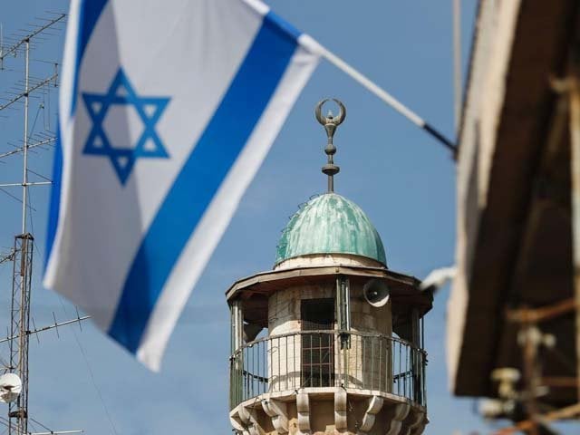 an israeli flag waves in front of the minaret of a mosque in the arab quarter of jerusalem 039 s old city november 14 israeli prime minister benjamin netanyahu said he backed a bill limiting the volume of calls to prayer from mosques a proposal government watchdogs called a threat to religious freedom
