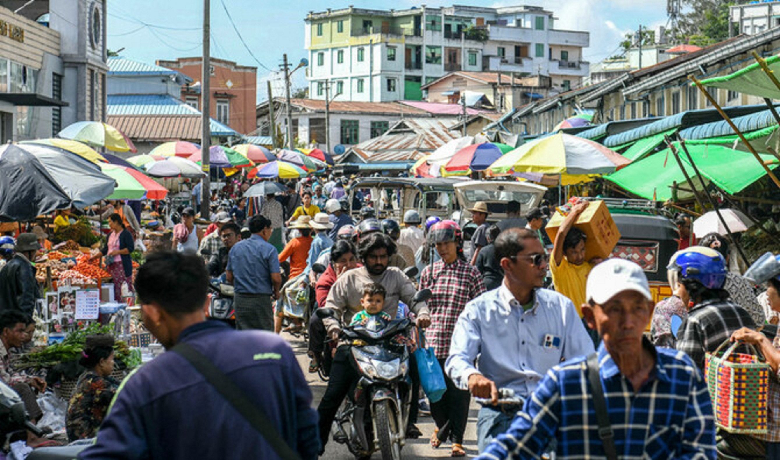 people make their way through a market in pyin oo lwin in myanmar s mandalay region on october 24 2024 photo afp