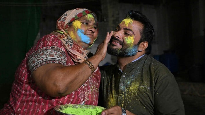 a mother paints the face of her son as they celebrate holi in mithi tharparkar district of sindh on march 13 2025 photo afp