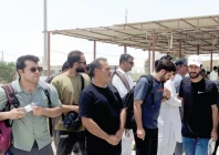 crew members of an iranian container vessel m v touska stand with their belongings after they were evacuated and handed over to iranian authorities at the gabd rimdan border crossing near gwadar photo reuters