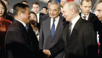 russia s president vladimir putin shakes hands with china s ambassador to russia zhang hanhui as foreign minister wang yi stands nearby during a welcoming ceremony at an airport in beijing photo reuters