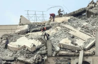 palestinian men stand atop a heavily damaged building in gaza city photo afp