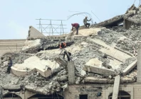 palestinian men stand atop a heavily damaged building in gaza city photo afp