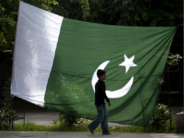 a boy walks past a pakistani flag in rawalpindi photo reuters