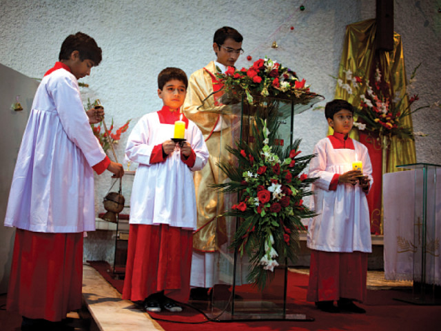 an altar boy awaits his procession before the start of night mass on christmas at lady fatima church on monday photo afp myra iqbal express an altar boy awaits his procession before the start of night mass on christmas at lady fatima church on monday photo afp myra iqbal express