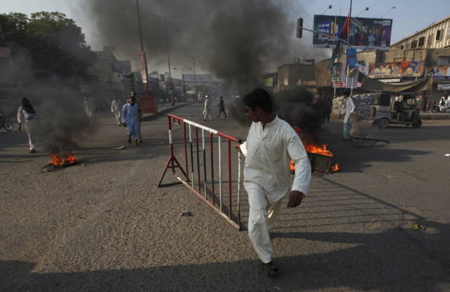a boy pulls an iron barrier during a protest against the killings by unidentified gunmen in karachi december 25 2012 photo reuters a boy pulls an iron barrier during a protest against the killings by unidentified gunmen in karachi december 25 2012 photo reuters