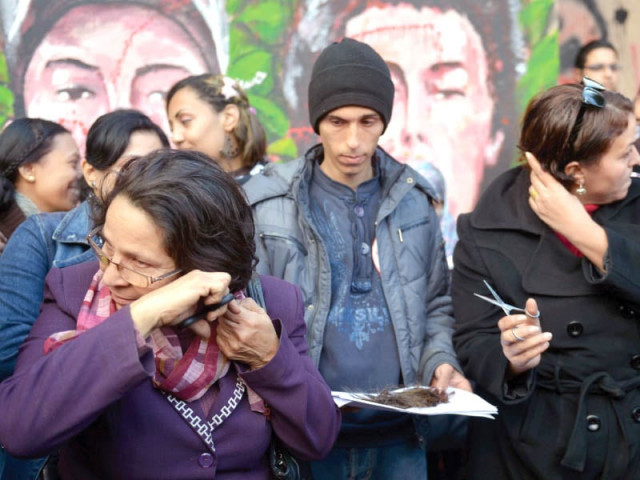 egyptian female protesters cut their hair during a demonstration mostly by egyptian women against their country s new constitution draft in cairo s tahrir square photo afp egyptian female protesters cut their hair during a demonstration mostly by egyptian women against their country s new constitution draft in cairo s tahrir square photo afp