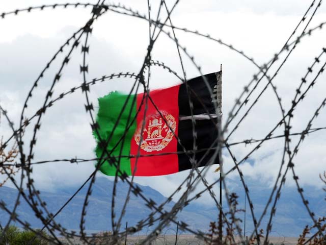 in this picture taken on march 17 2014 the afghan national flag flutters in the wind behind barbed wire at a forward operating base where soldiers attached to the 4th brigade 201 army corps of the ana live in khogyani district photo getty