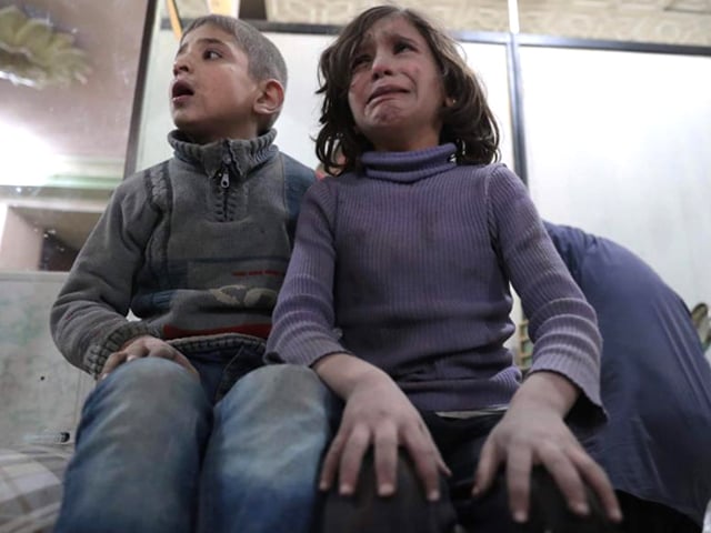 syrian children wait to receive treatment at a makeshift clinic following reported air strikes by government forces in the rebel held town of douma on the eastern outskirts of damascus photo afp