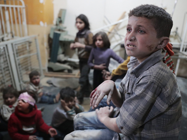 syrian children wait to receive treatment at a makeshift clinic following reported air strikes by government forces in the rebel held town of douma on the eastern outskirts of damascus photo afp