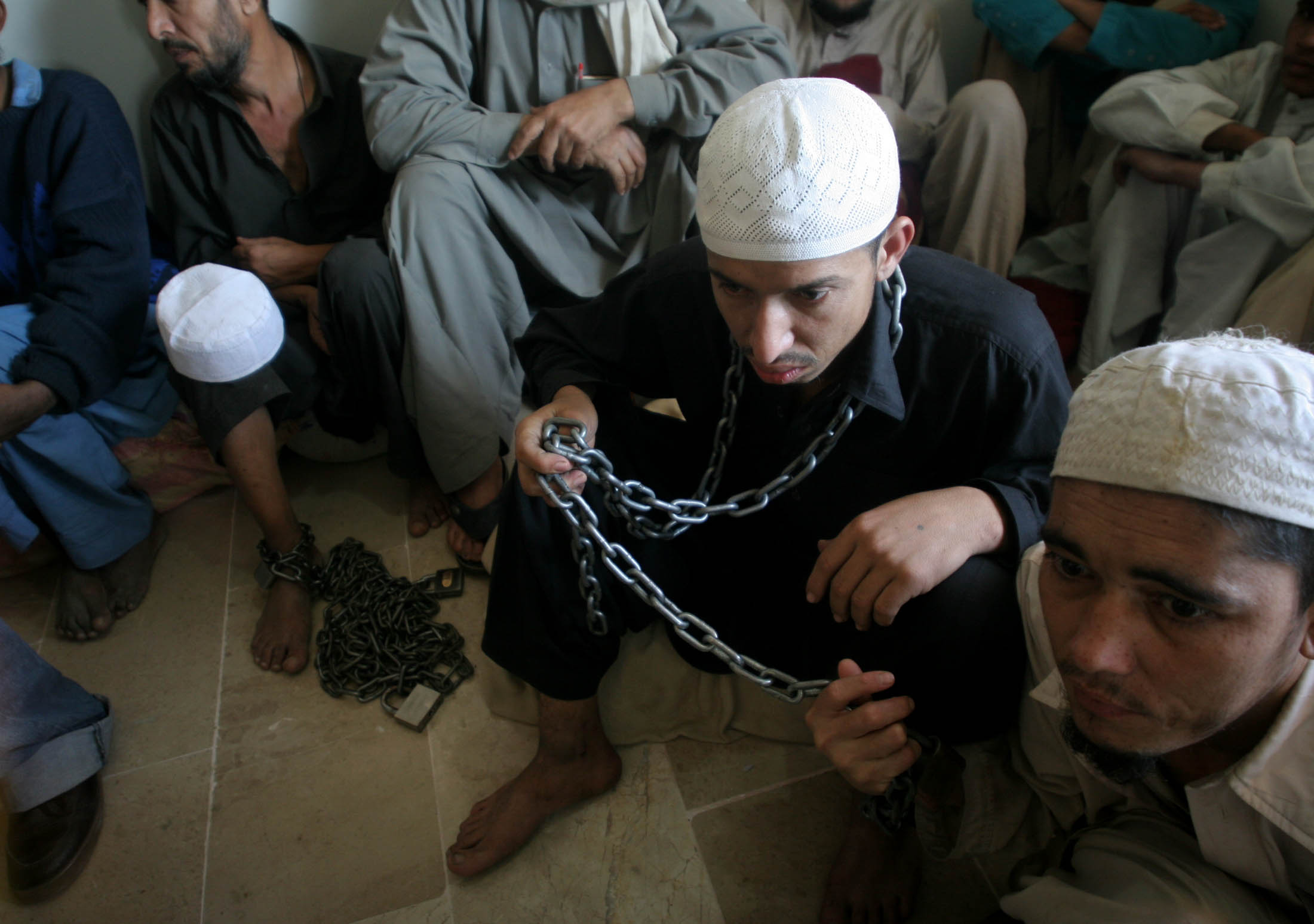 juvenile students of a religious seminary sit chained in police detention photo athar khan express file