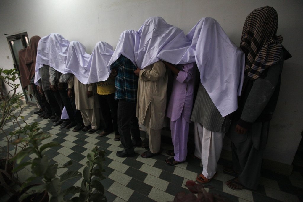 men covered with a roll of cloth stand in line at the crime investigation department cid after their arrest in karachi january 2 2013 photo reuters
