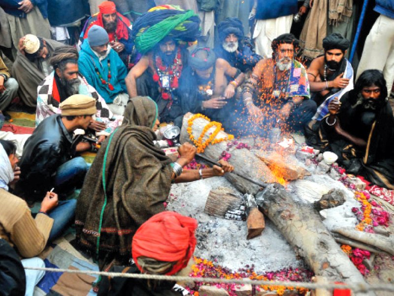 devotees sit around a fire photo mehmood qureshi express