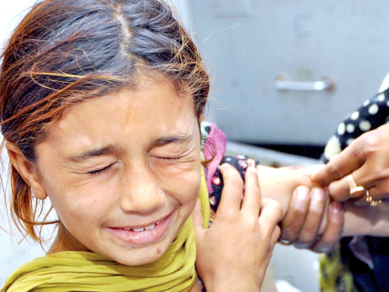 a female health worker administers the measles vaccine to a child during the anti measles campaign at the bhains colony government dispensary in larkana on thursday photo app