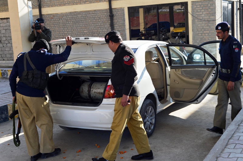 policemen inspect a car after unknown armed men shot dead two men at a market in it in charsadda on january 5 2012 photo afp